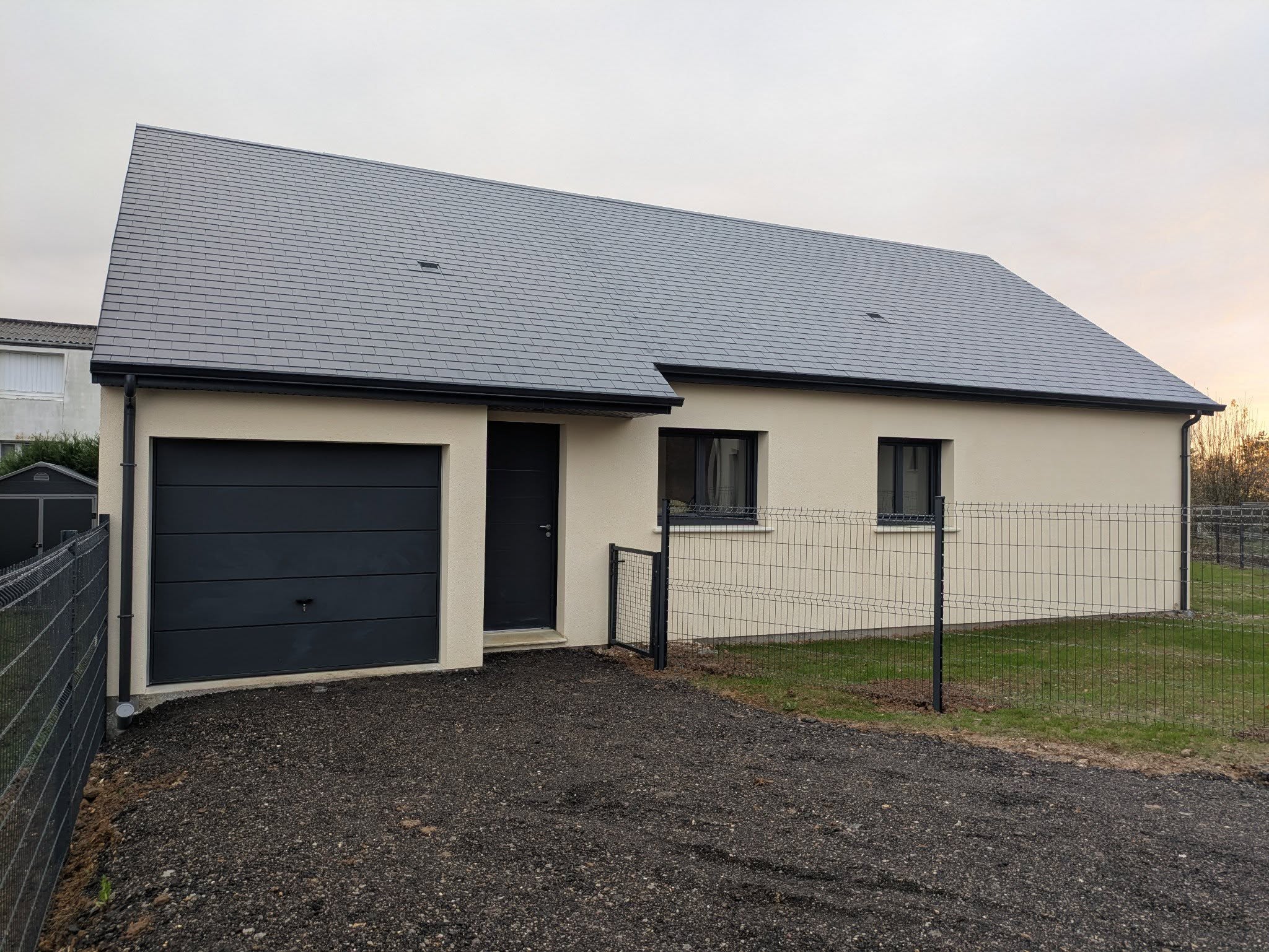 Maison de plain-pied neuve avec garage, enduit clair et toiture en ardoise