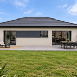 Maison contemporaine de plain-pied en L, côté jardin avec terrasse